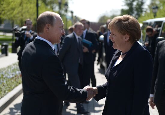 Vladimir Putin and German Chancellor Angela Merkel lay flowers at Tomb of the Unknown Soldier