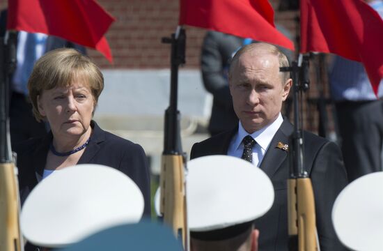 Vladimir Putin and German Chancellor Angela Merkel lay flowers at Tomb of the Unknown Soldier