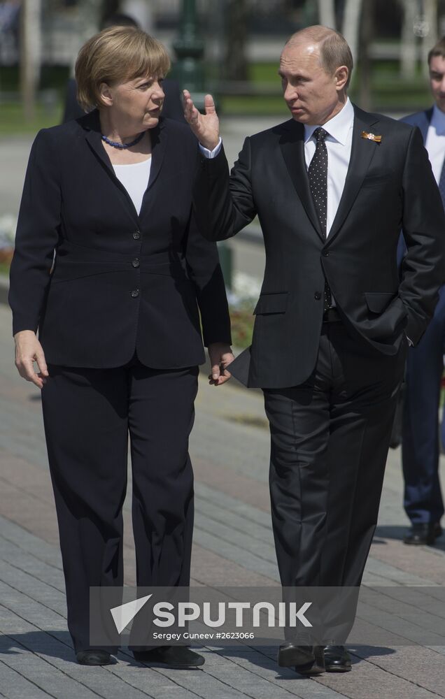 Vladimir Putin and German Chancellor Angela Merkel lay flowers at Tomb of the Unknown Soldier