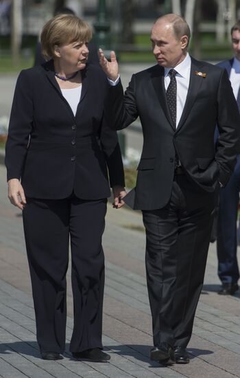 Vladimir Putin and German Chancellor Angela Merkel lay flowers at Tomb of the Unknown Soldier