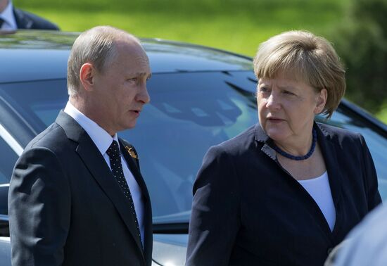 Vladimir Putin and German Chancellor Angela Merkel lay flowers at Tomb of the Unknown Soldier