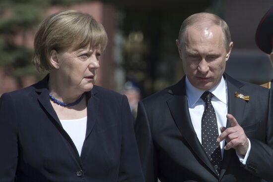 Vladimir Putin and German Chancellor Angela Merkel lay flowers at Tomb of the Unknown Soldier