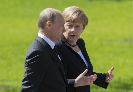 Vladimir Putin and German Chancellor Angela Merkel lay flowers at Tomb of the Unknown Soldier