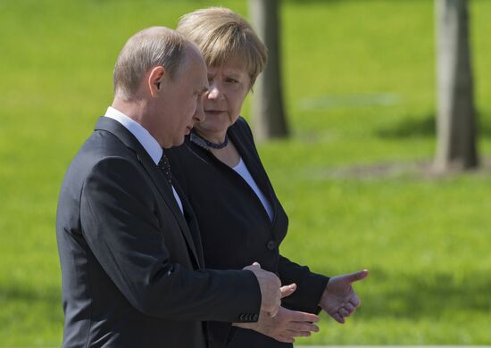 Vladimir Putin and German Chancellor Angela Merkel lay flowers at Tomb of the Unknown Soldier