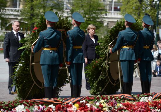 Vladimir Putin and German Chancellor Angela Merkel lay flowers at Tomb of the Unknown Soldier