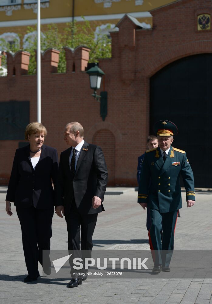 Vladimir Putin and German Chancellor Angela Merkel lay flowers at Tomb of the Unknown Soldier