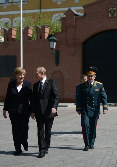 Vladimir Putin and German Chancellor Angela Merkel lay flowers at Tomb of the Unknown Soldier