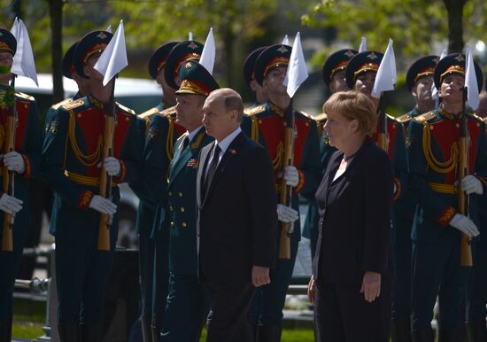 Vladimir Putin and German Chancellor Angela Merkel lay flowers at Tomb of the Unknown Soldier