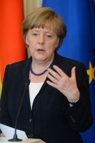 Vladimir Putin and German Chancellor Angela Merkel lay flowers at Tomb of the Unknown Soldier