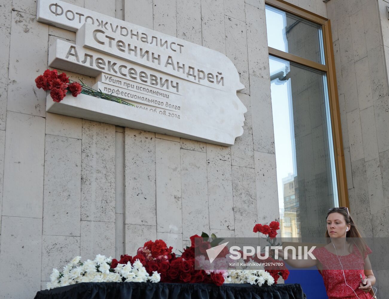 Leaving flowers by plaque in memory of Andrei Stenin