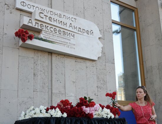 Leaving flowers by plaque in memory of Andrei Stenin