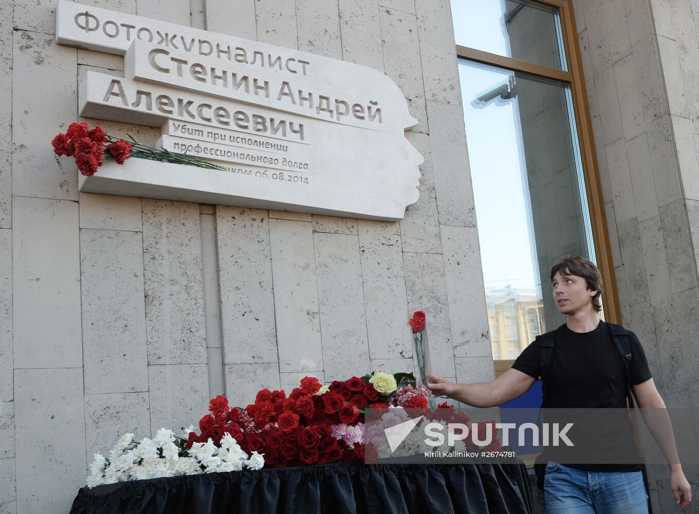 Leaving flowers by plaque in memory of Andrei Stenin