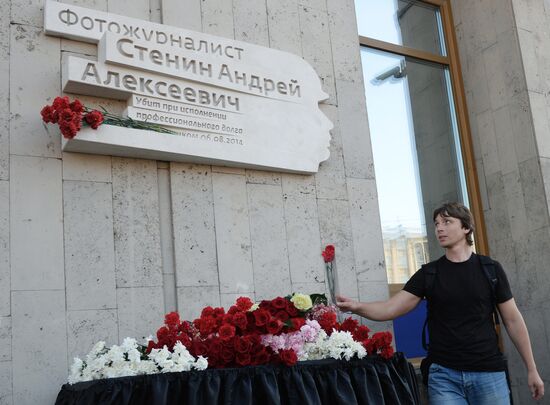 Leaving flowers by plaque in memory of Andrei Stenin