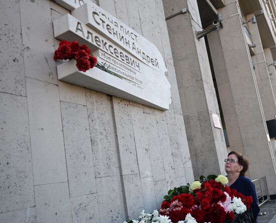Leaving flowers by plaque in memory of Andrei Stenin