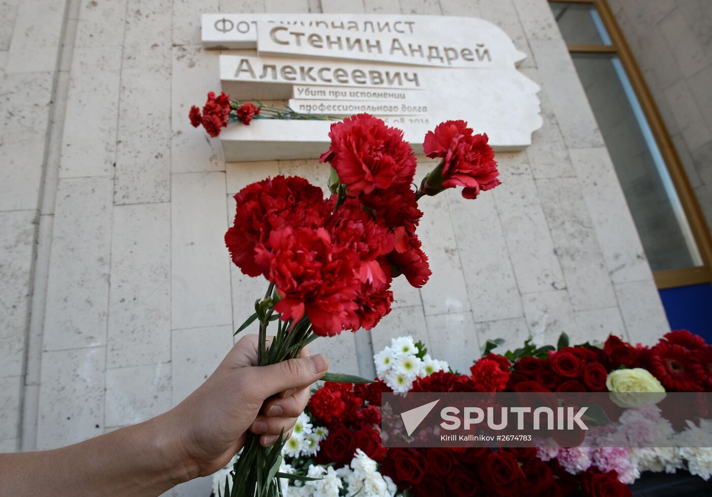Leaving flowers by plaque in memory of Andrei Stenin