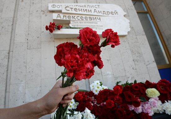 Leaving flowers by plaque in memory of Andrei Stenin