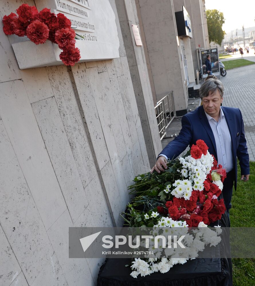 Leaving flowers by plaque in memory of Andrei Stenin