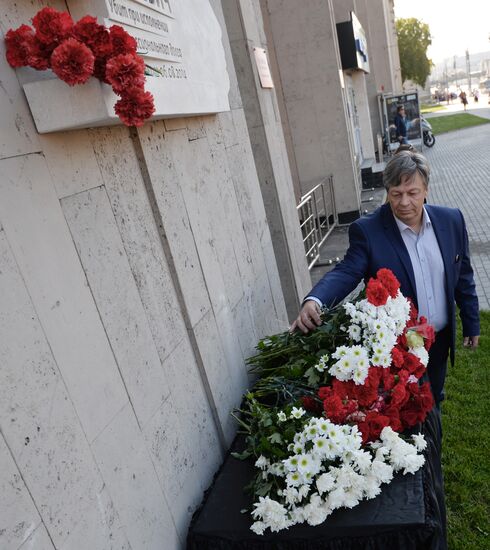 Leaving flowers by plaque in memory of Andrei Stenin