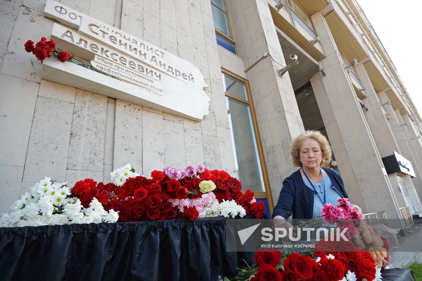 Leaving flowers by plaque in memory of Andrei Stenin