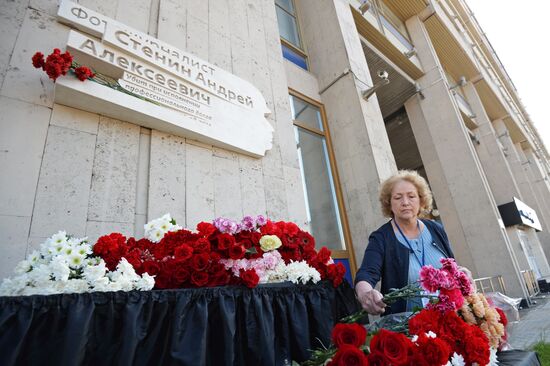Leaving flowers by plaque in memory of Andrei Stenin