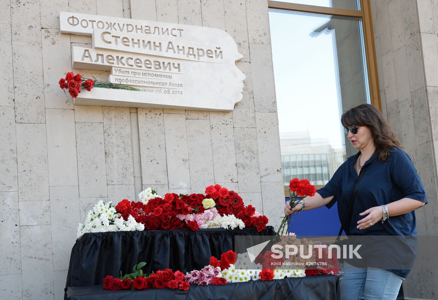 Leaving flowers by plaque in memory of Andrei Stenin