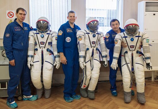 ISS-45/46 and Visiting Expedition 18 primary crew try on space suits and inspect space ship