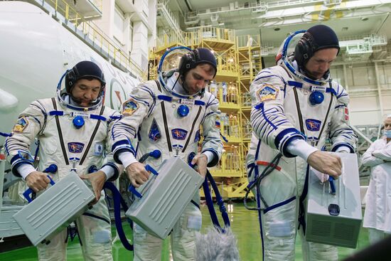 ISS-45/46 and Visiting Expedition 18 primary crew try on space suits and inspect space ship