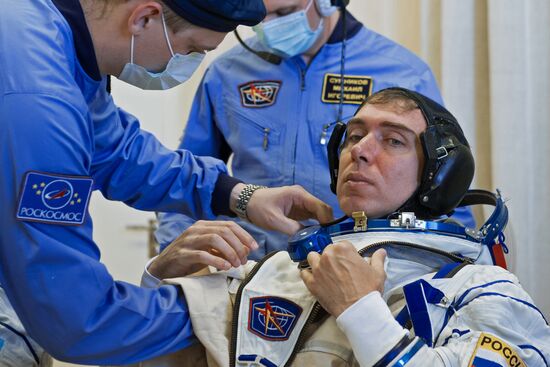ISS-45/46 and Visiting Expedition 18 primary crew try on space suits and inspect space ship