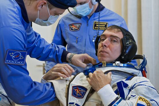 ISS-45/46 and Visiting Expedition 18 primary crew try on space suits and inspect space ship