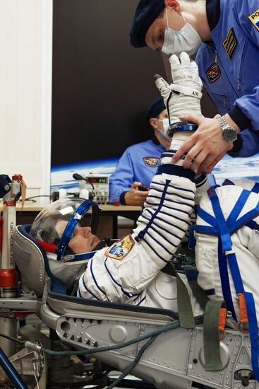 ISS-45/46 and Visiting Expedition 18 primary crew try on space suits and inspect space ship