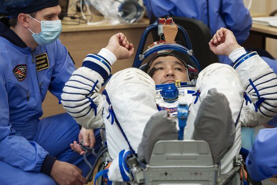 ISS-45/46 and Visiting Expedition 18 primary crew try on space suits and inspect space ship