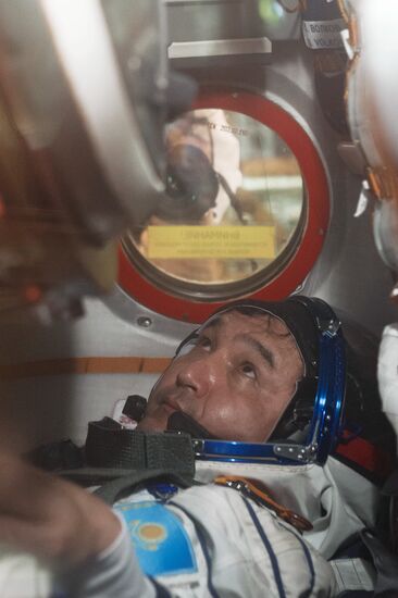 ISS-45/46 and Visiting Expedition 18 primary crew try on space suits and inspect space ship