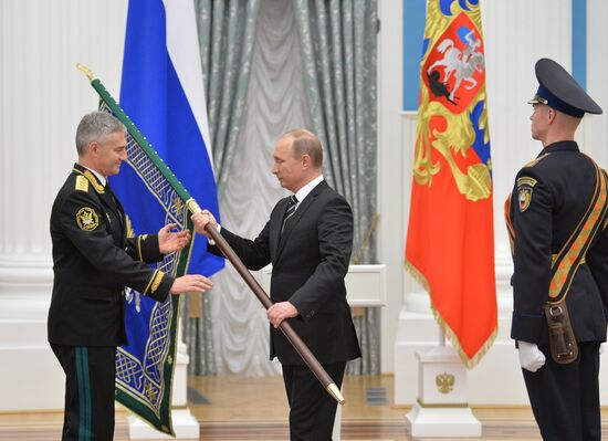 Russian President Vladimir Putin presents banner of Federal Bailiff Service