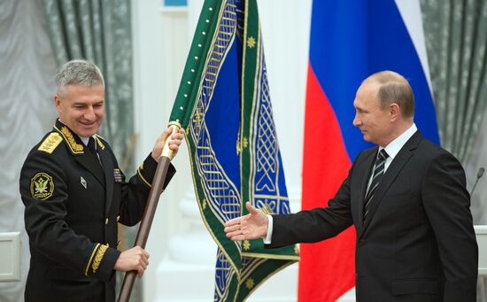 Russian President Vladimir Putin presents banner of Federal Bailiff Service