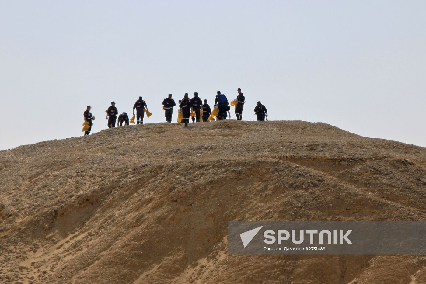 Rescuers search through the crash site of Russian Airbus A321 in Egypt