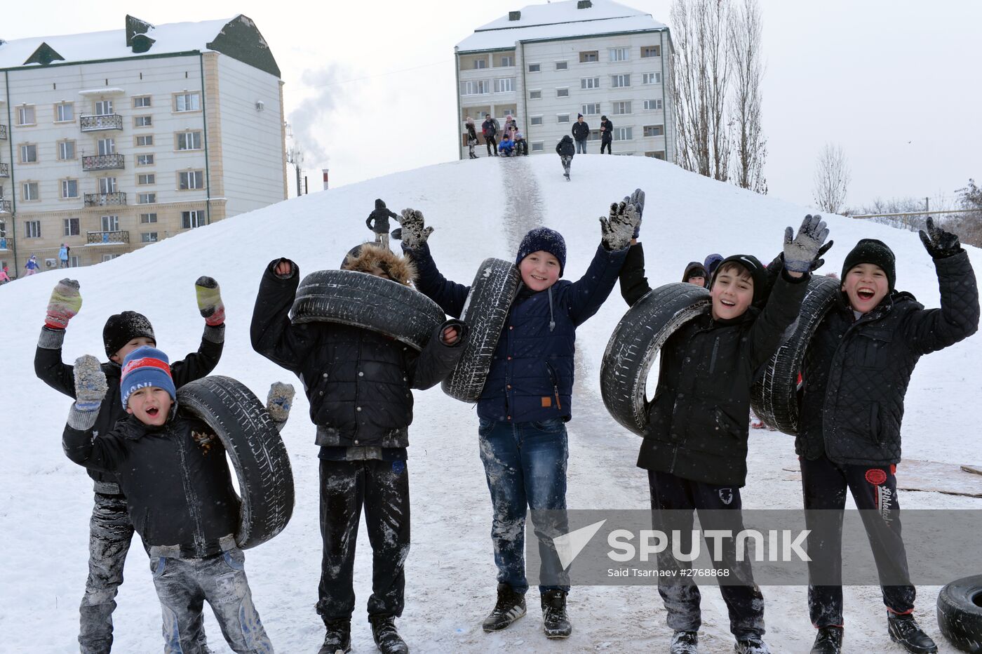 Children slide down ice slope in Grozny