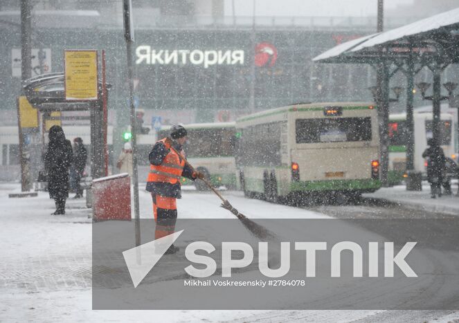 A housing services worker removing snow from the pavement at a public transport stop near Shchukinskaya metro station in Moscow. Location: Russia, Moscow. Author: Mikhail Voskresenskiy/Sputnik. Moscow roads treated with deicing chemicals