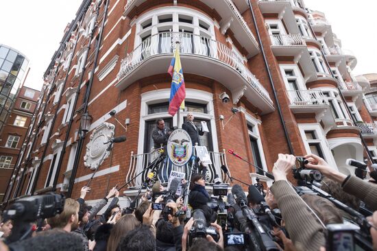 Julian Assange addresses journalists and protesters from Ecuadoran Embassy in London