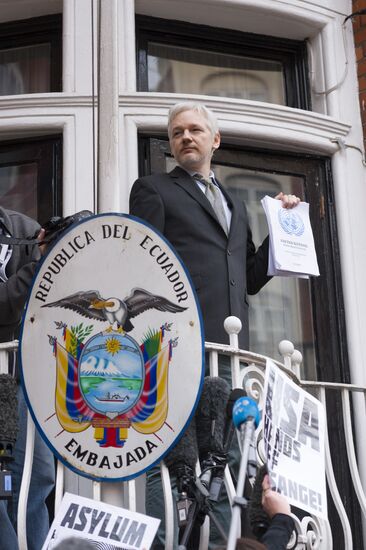 Julian Assange addresses journalists and protesters from Ecuadoran Embassy in London