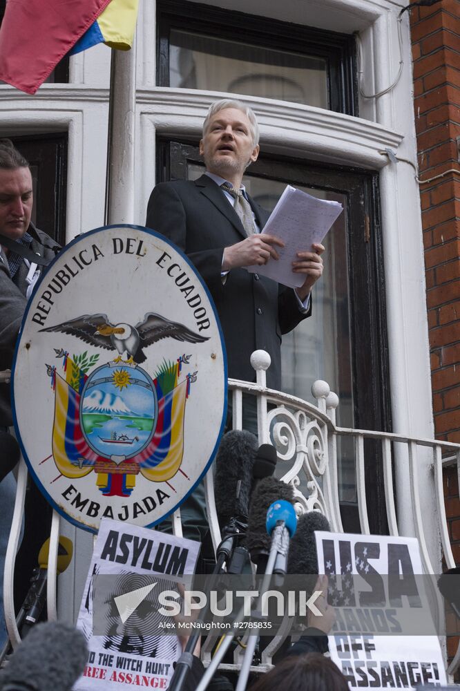 Julian Assange addresses journalists and protesters from Ecuadoran Embassy in London