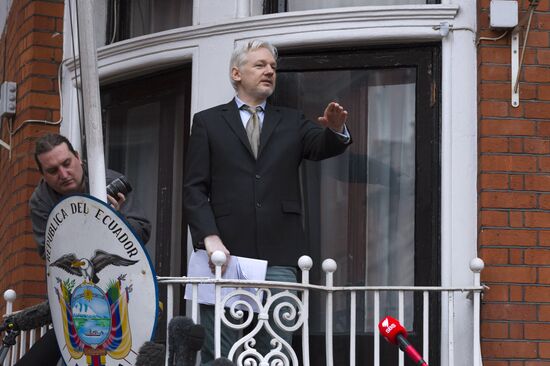 Julian Assange addresses journalists and protesters from Ecuadoran Embassy in London