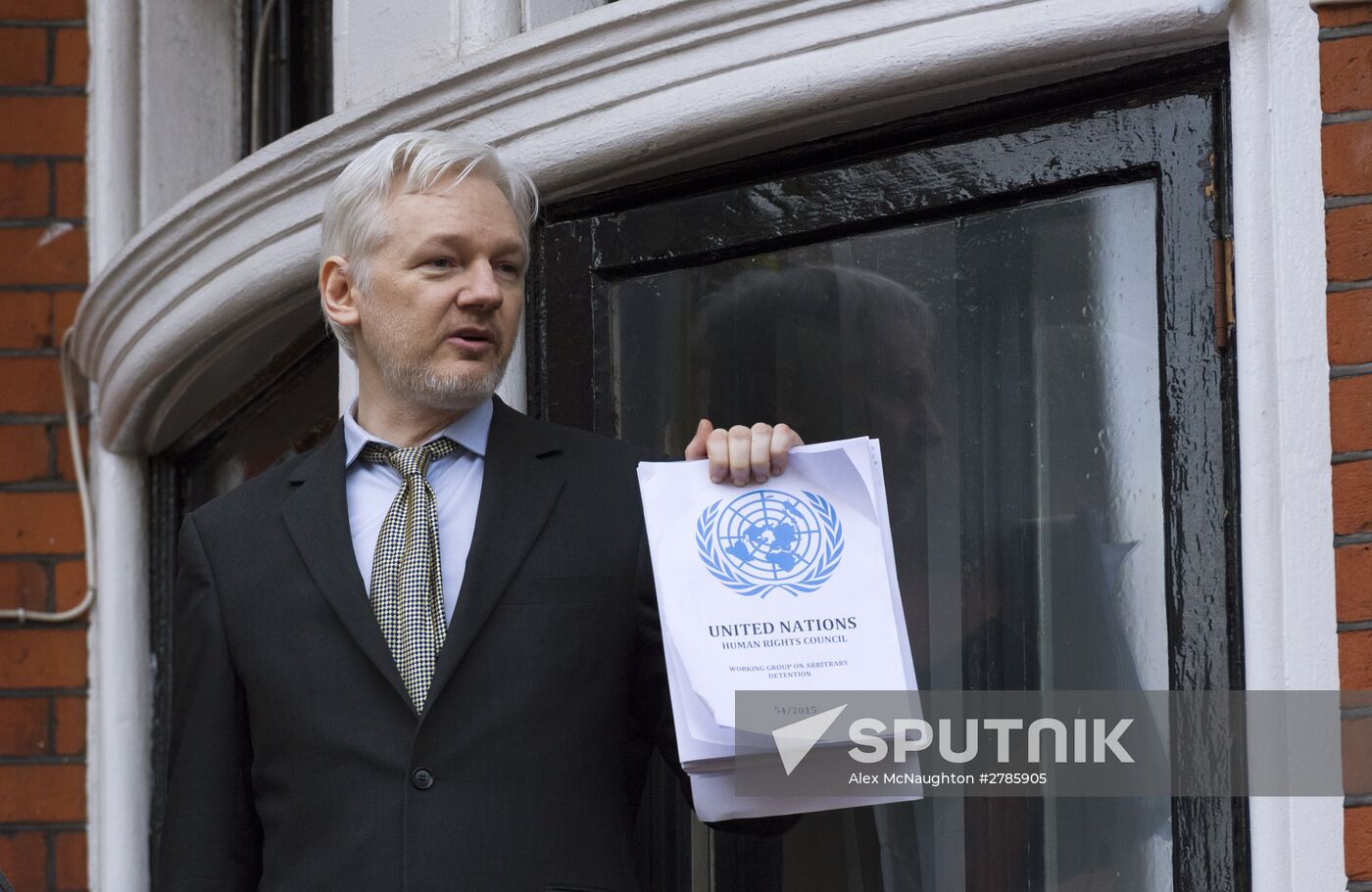Julian Assange addresses journalists and protesters from Ecuadoran Embassy in London