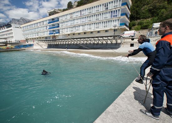 Diver examinsation and bottom cleansing off Crimean beach shore