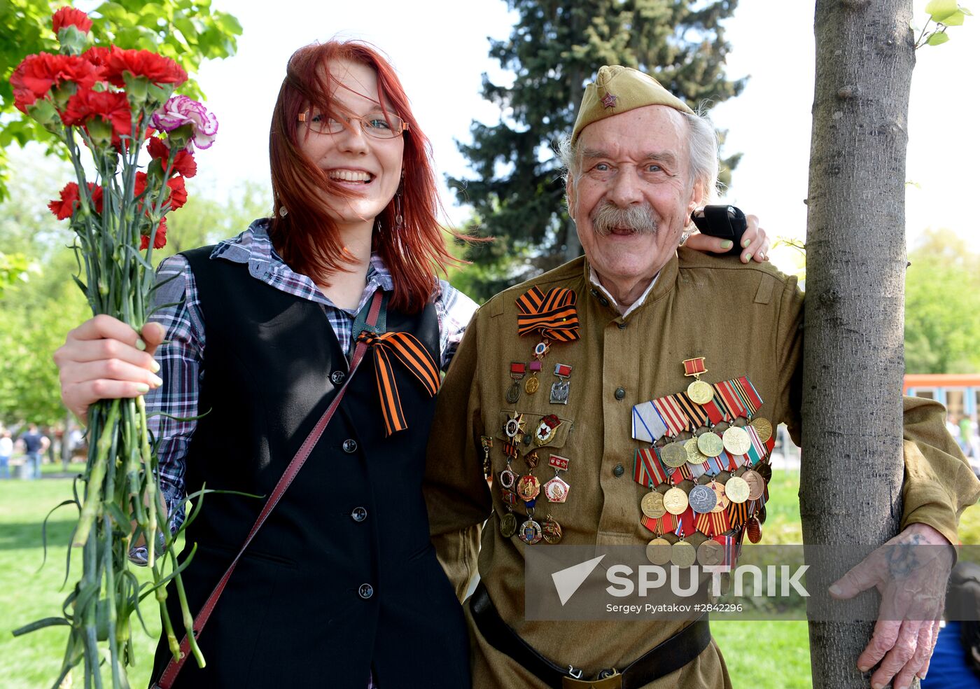 A young woman is photographed with a veteran of the Great Patriotic War during the celebration of the 71st anniversary of the Victory in the Great Patriotic War of 1941-1945, in Moscow's Gorky Central Park of Culture and Recreation. Location: Russia, Moscow. Author: Sergey Pyatakov/Sputnik. Celebration of 71st anniversary of Victory in 1941-1945 Great Patriotic War