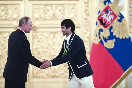 President Vladimir Putin gives government awards to Olympic medalists