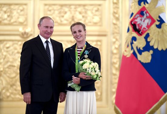 President Vladimir Putin gives government awards to Olympic medalists