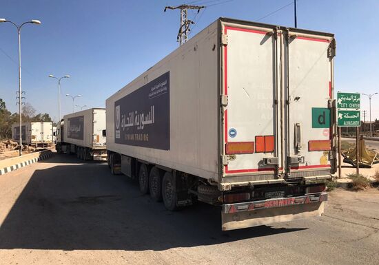 Deir ez-Zor residents welcome a truck convoy of medicines and food