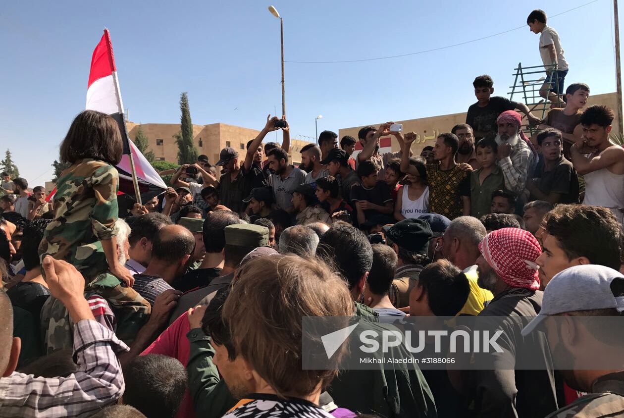 Deir ez-Zor residents welcome a truck convoy of medicines and food
