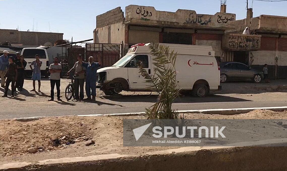 Deir ez-Zor residents welcome a truck convoy of medicines and food