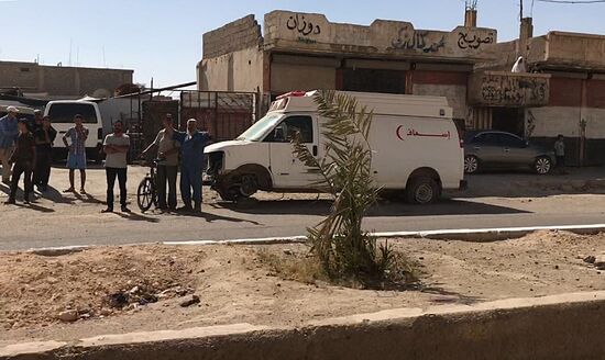 Deir ez-Zor residents welcome a truck convoy of medicines and food